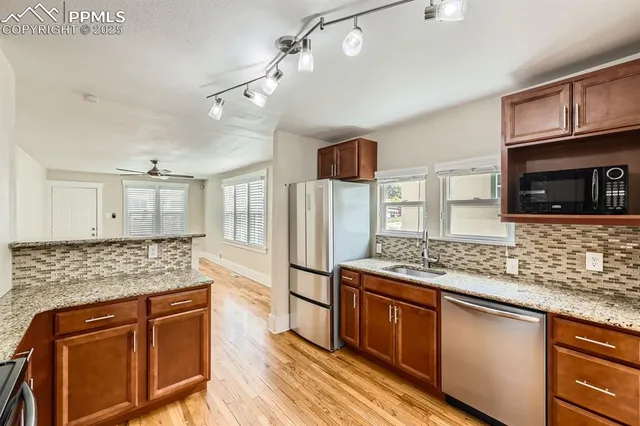 a kitchen with stainless steel appliances granite countertop wooden cabinets microwave and stove
