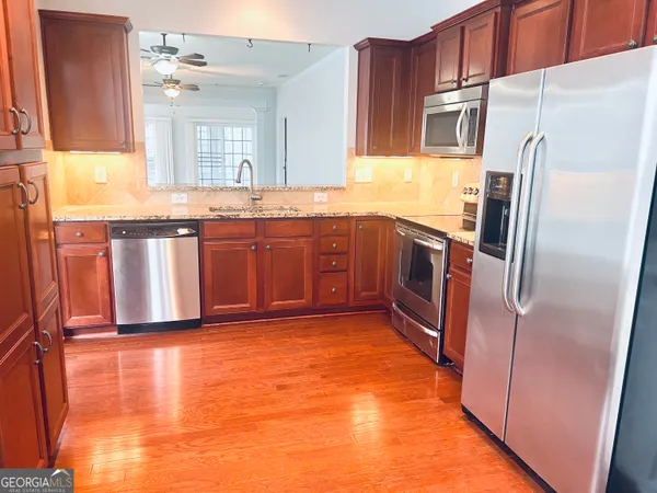 a kitchen with stainless steel appliances granite countertop a refrigerator and a sink