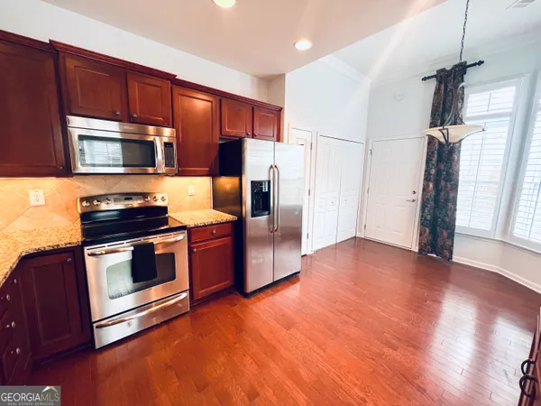 a kitchen with granite countertop wooden floors and stainless steel appliances