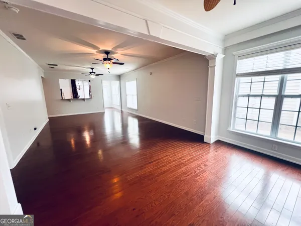 a view of a livingroom with wooden floor and a ceiling fan