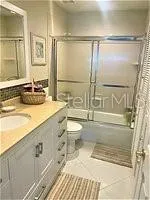 a bathroom with a granite countertop sink mirror vanity and toilet