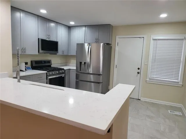 a kitchen with stainless steel appliances a refrigerator microwave stove sink and cabinets