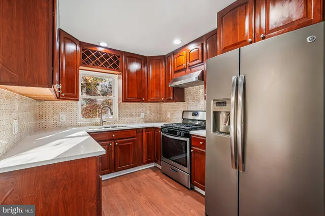 a kitchen with stainless steel appliances granite countertop a stove a sink dishwasher and a refrigerator