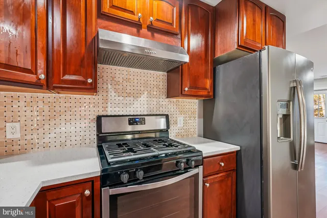 a kitchen with stainless steel appliances granite countertop a refrigerator and a stove