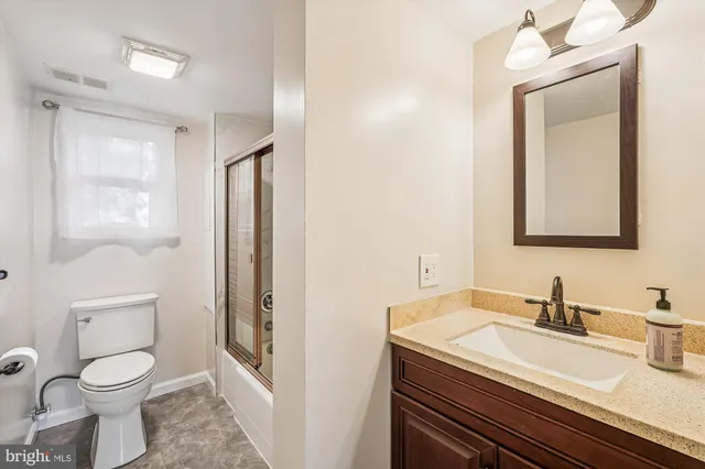 a bathroom with a granite countertop sink toilet and shower