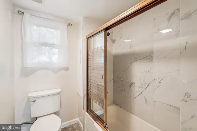 a bathroom with a toilet and a shower