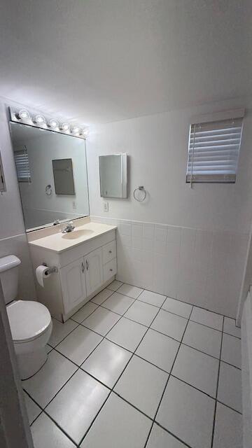 2234 Northeast Pine Ridge Street Jensen Beach, FL 34957 - Photo 9 of 18 a bathroom with a sink a toilet and mirror