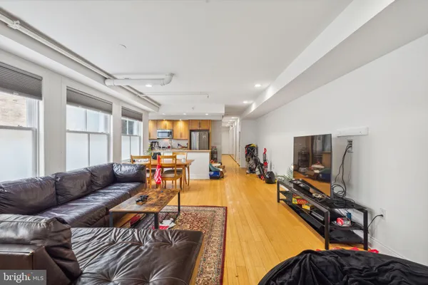 a living room with furniture a flat screen tv and a window