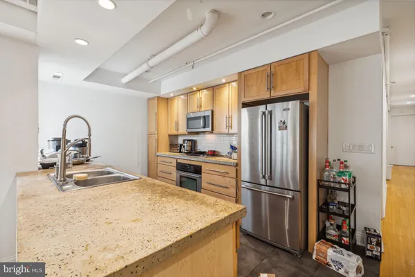 a kitchen with refrigerator a stove and a sink