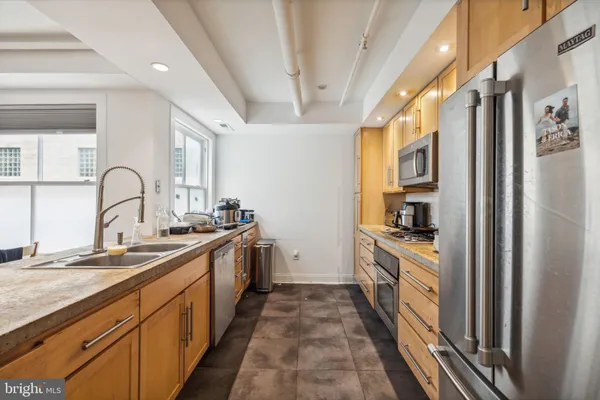 a large kitchen with stainless steel appliances granite countertop a lot of counter space and wooden floors
