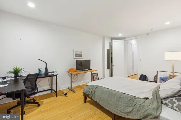 a bedroom with a bed and a potted plant on the dresser