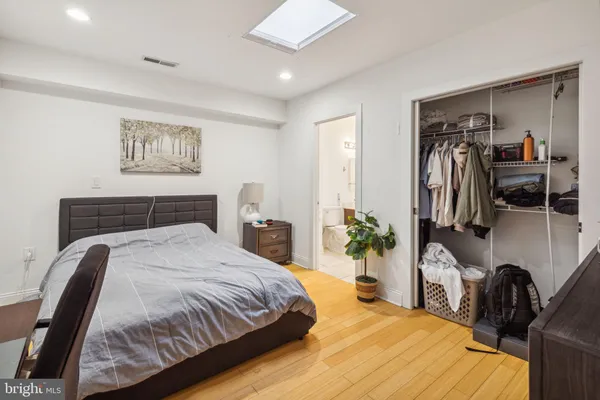 a bedroom with a bed with chair and dresser