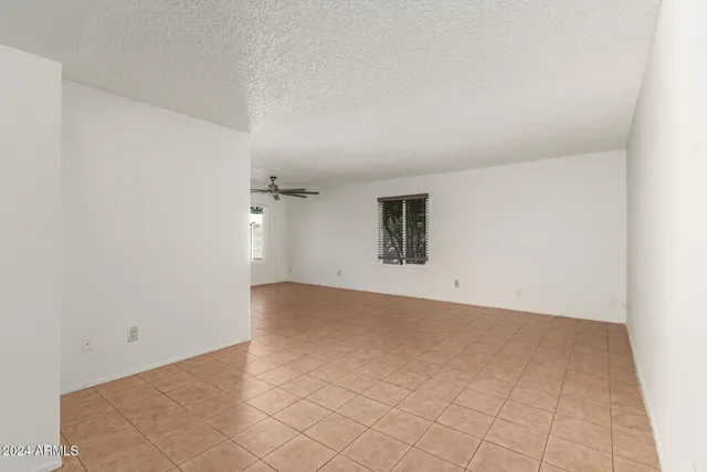 an empty room with a ceiling fan and carpet