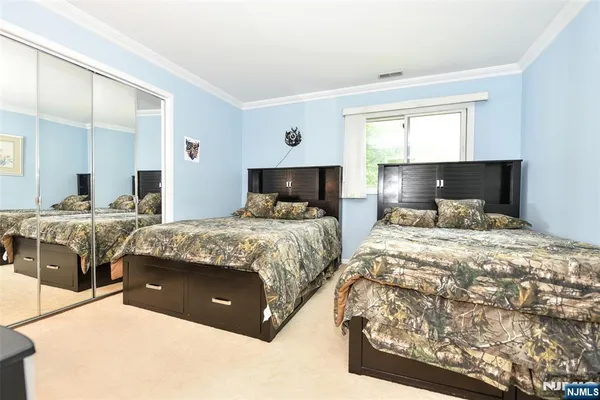 a bedroom with a large bed and wooden floor