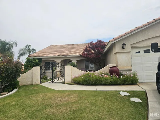 a front view of a house with a garden and yard
