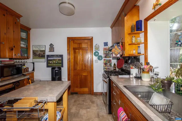 a kitchen with a stove a sink and a wooden cabinets