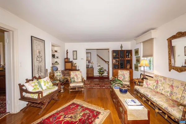 a living room with furniture a wooden floor and next to a window