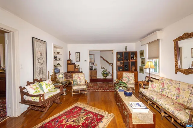 a living room with furniture a wooden floor and next to a window