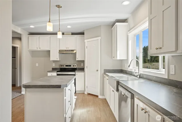 a kitchen with stainless steel appliances granite countertop a sink stove and refrigerator