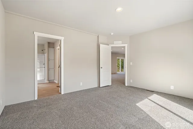 a view of an empty room with closet and a window
