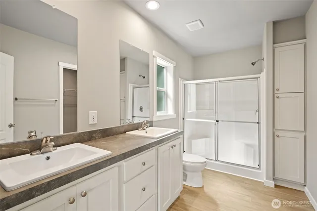 a bathroom with a double vanity sink toilet and shower