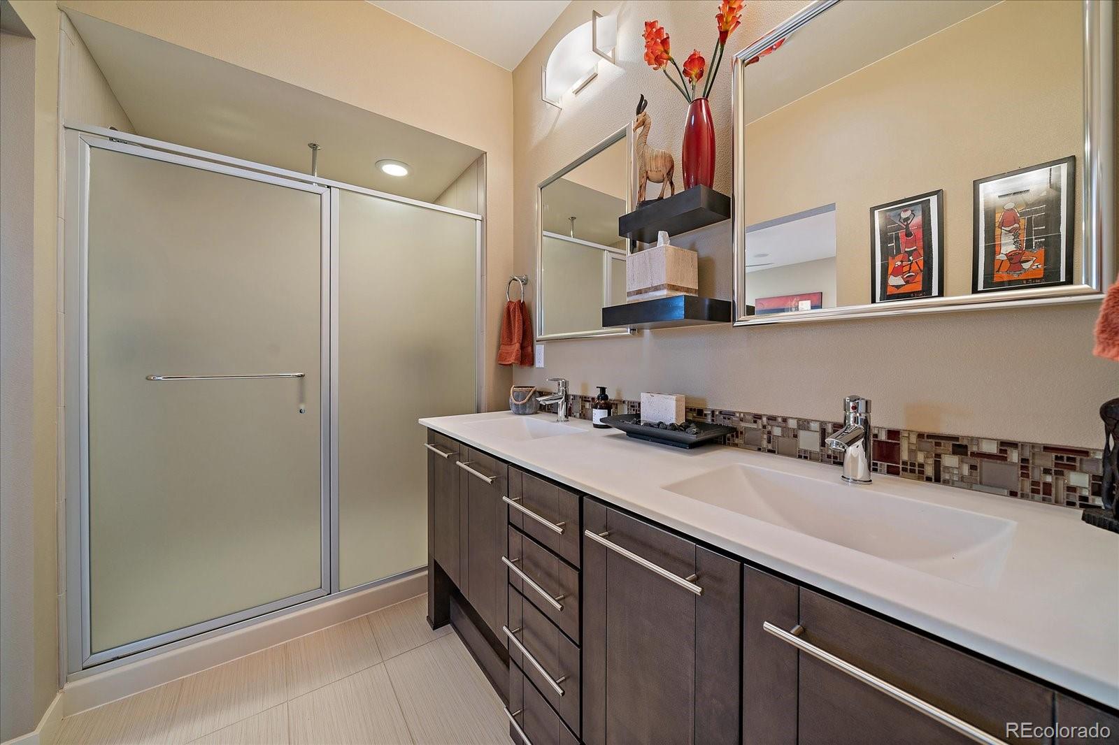 9717 Dunning Circle Highlands Ranch, CO 80126 - Photo 19 of 38 a bathroom with a sink double vanity and a shower