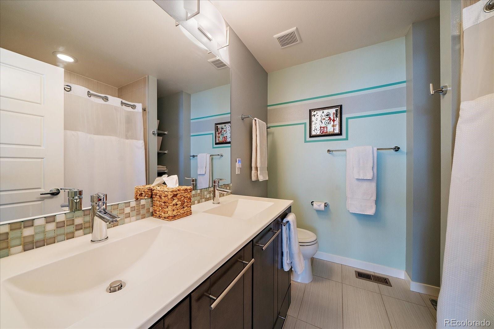 9717 Dunning Circle Highlands Ranch, CO 80126 - Photo 27 of 38 a bathroom with a sink a toilet and shower