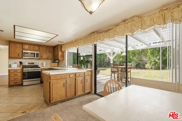 a open kitchen with stainless steel appliances granite countertop a stove top oven a sink and a refrigerator