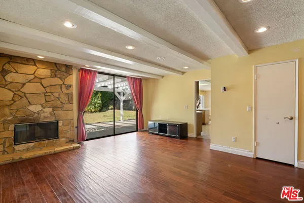 a view of empty room with wooden floor and fireplace
