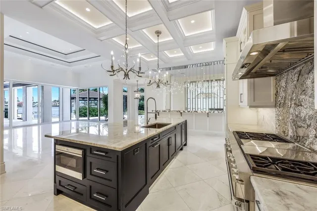 a kitchen with stainless steel appliances granite countertop a stove and a view of living room