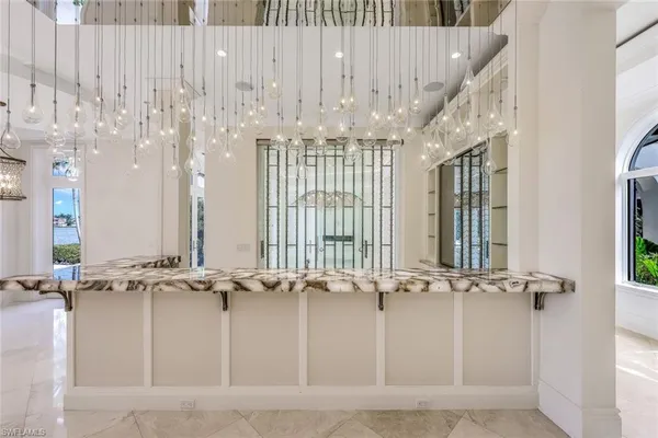 a view of a hallway with furniture and a chandelier