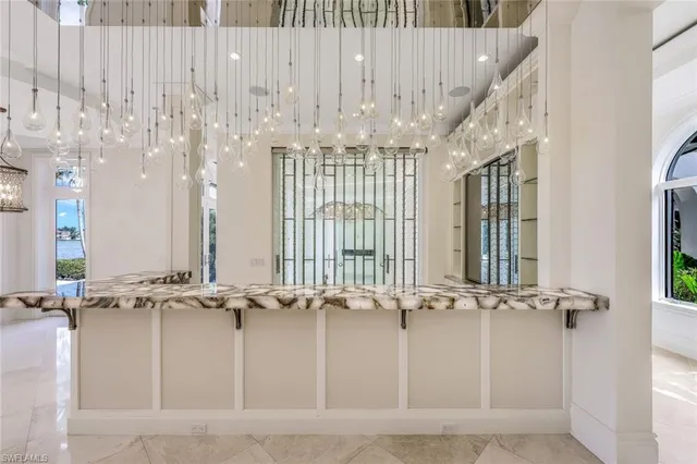 a view of a hallway with furniture and a chandelier