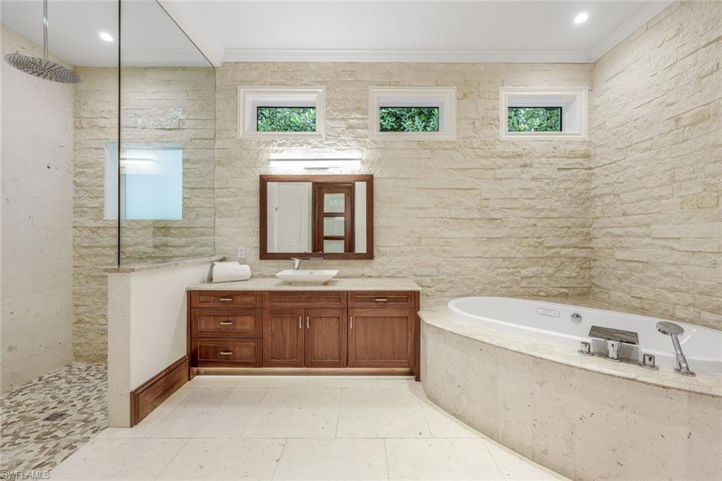 970 Aqua Circle Naples, FL 34102 - Photo 28 of 43 a bathroom with a granite countertop bathtub sink mirror and toilet