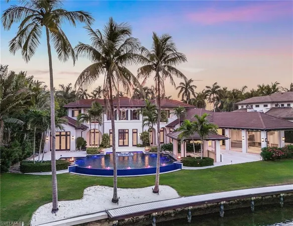 front view of a house with a yard and palm trees