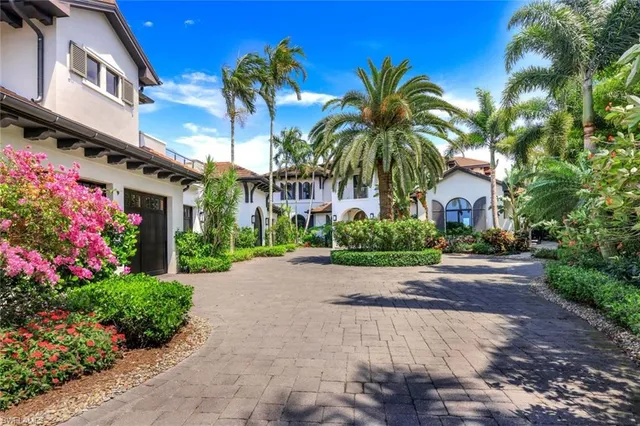 a view of a house with a yard and potted plants