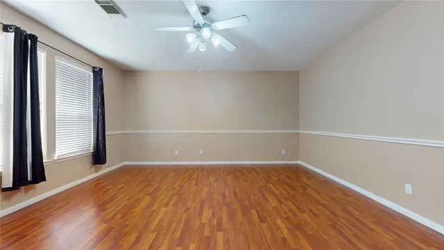 wooden floor in an empty room with a window