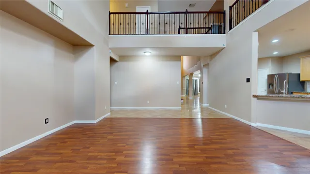 a view of a room with wooden floor and a ceiling fan