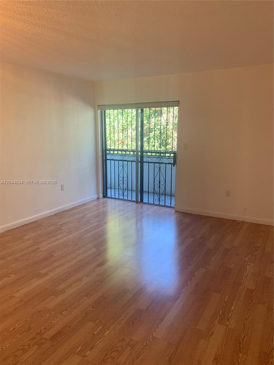 2460 Southwest 18th Avenue, Unit 1205 Miami, FL 33133 - Photo 6 of 21 a view of an empty room with wooden floor and a window