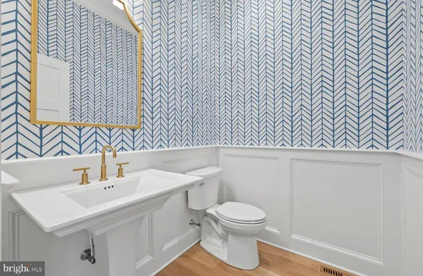 a bathroom with a sink a toilet and mirror