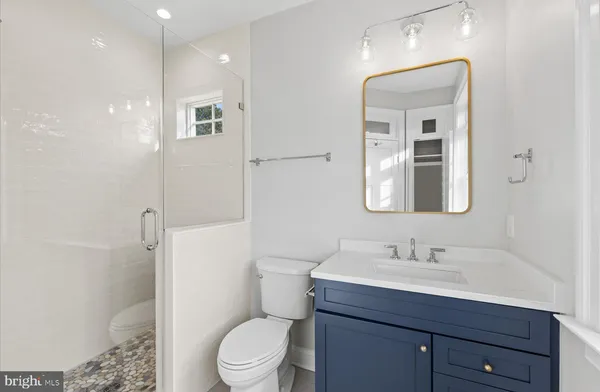 a bathroom with a toilet a sink a mirror and a shower