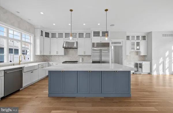 a large kitchen with stainless steel appliances kitchen island granite countertop a large cabinets a sink and wooden floor
