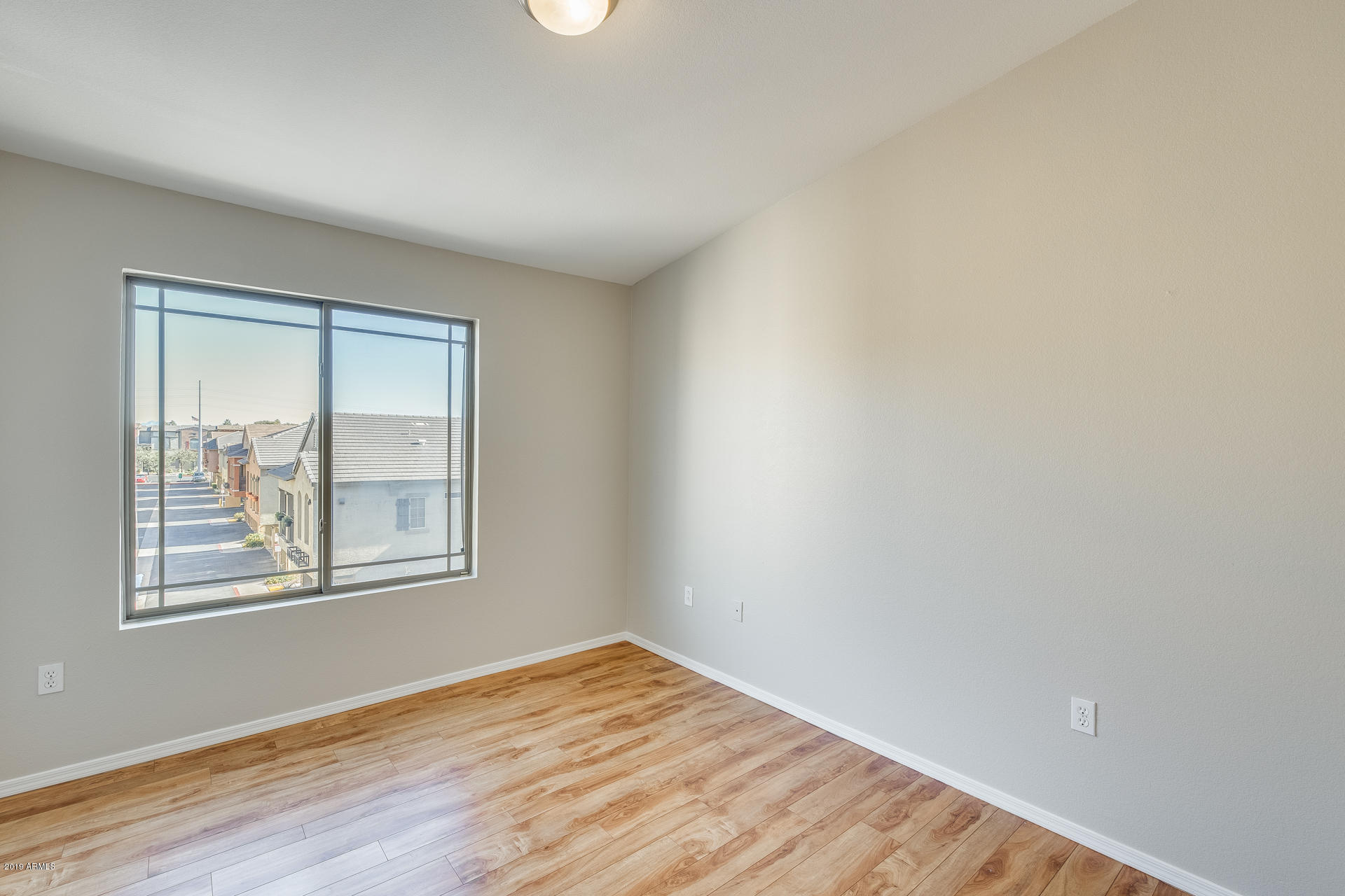 2401 East Rio Salado Parkway, Unit 1124 Tempe, AZ 85288 - Photo 27 of 32 an empty room with wooden floor and windows
