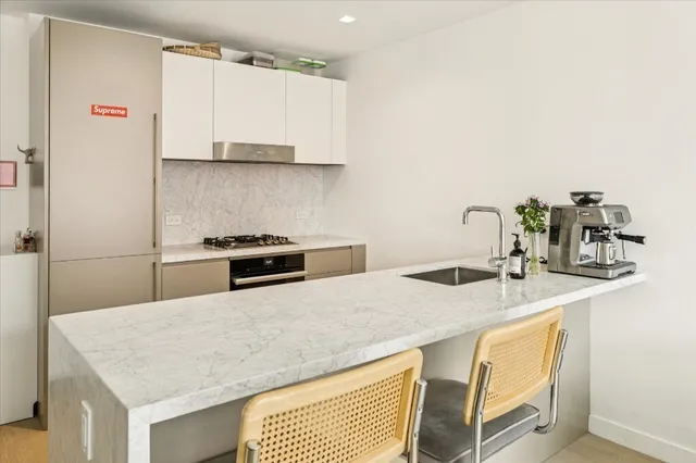 a kitchen with stainless steel appliances granite countertop a sink and white cabinets
