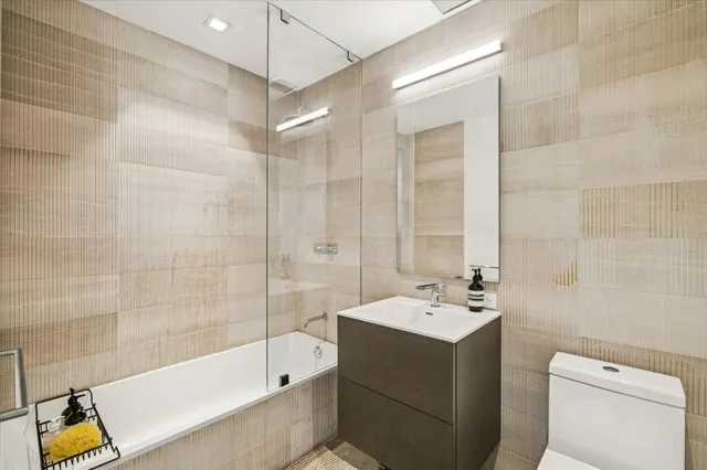 a bathroom with a tub sink toilet and mirror