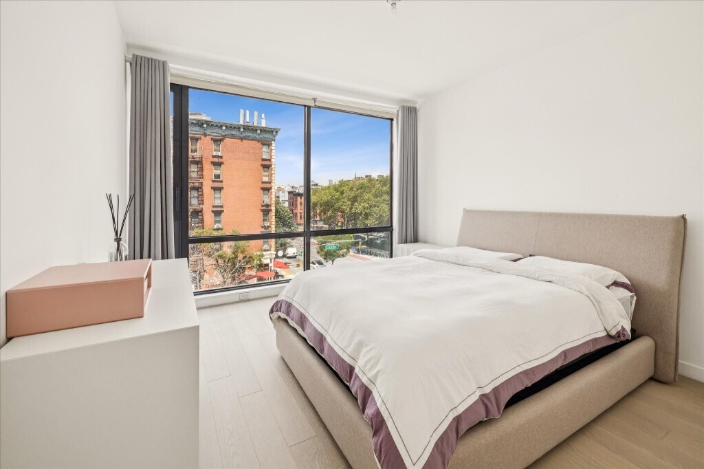 75 1st Avenue, Unit 4B Manhattan, NY 10003 - Photo 5 of 6 a large bed sitting in a bedroom next to a window