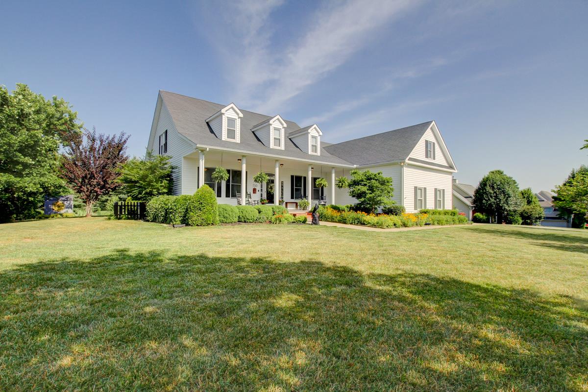 a front view of a house with yard and green space