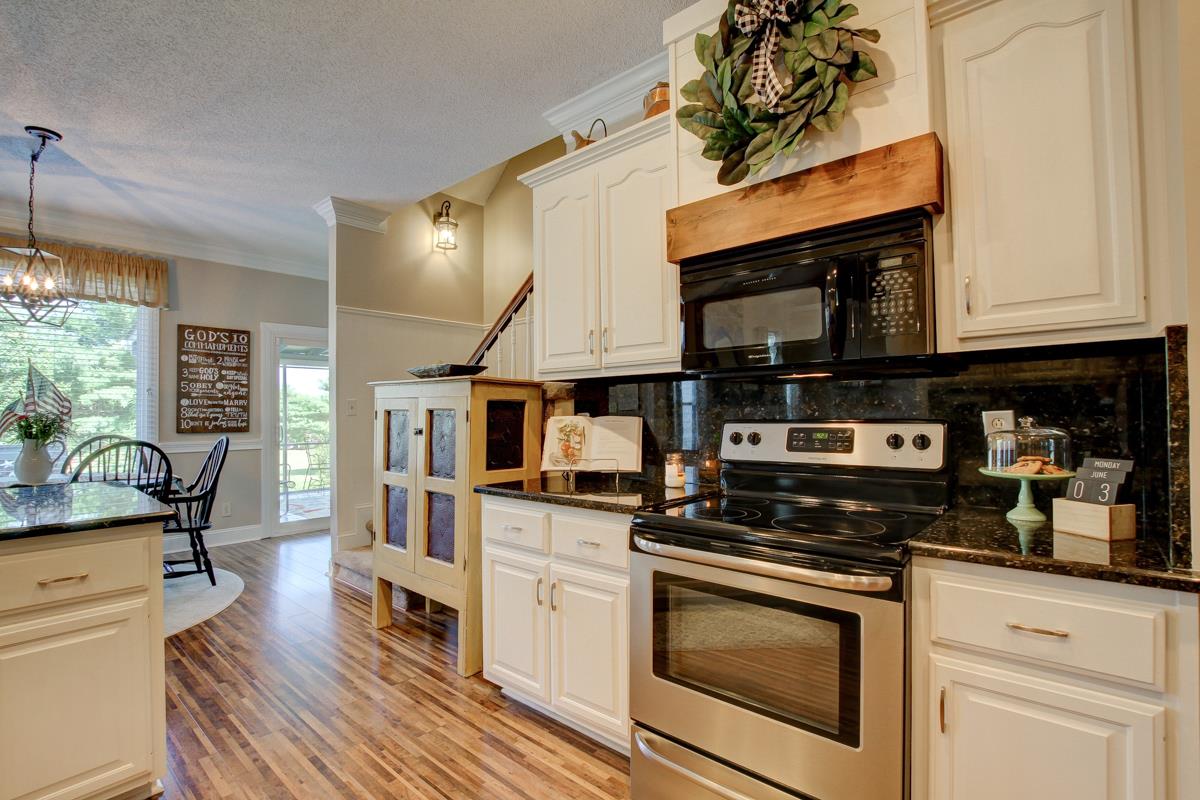 730 Dixie Bee Road Clarksville, TN 37043 - Photo 11 of 30 a kitchen with stainless steel appliances kitchen island granite countertop a stove a sink and white cabinets