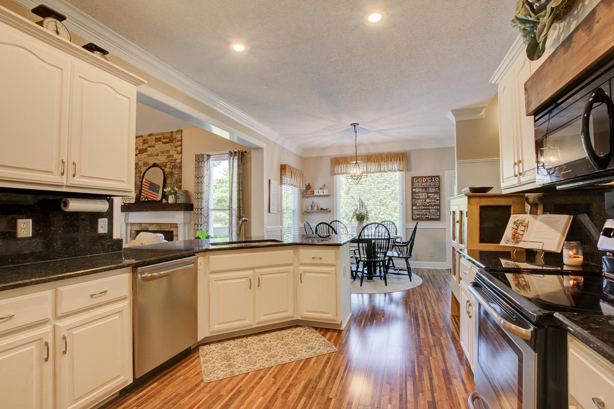730 Dixie Bee Road Clarksville, TN 37043 - Photo 9 of 30 a kitchen with stainless steel appliances granite countertop a stove and a wooden floors