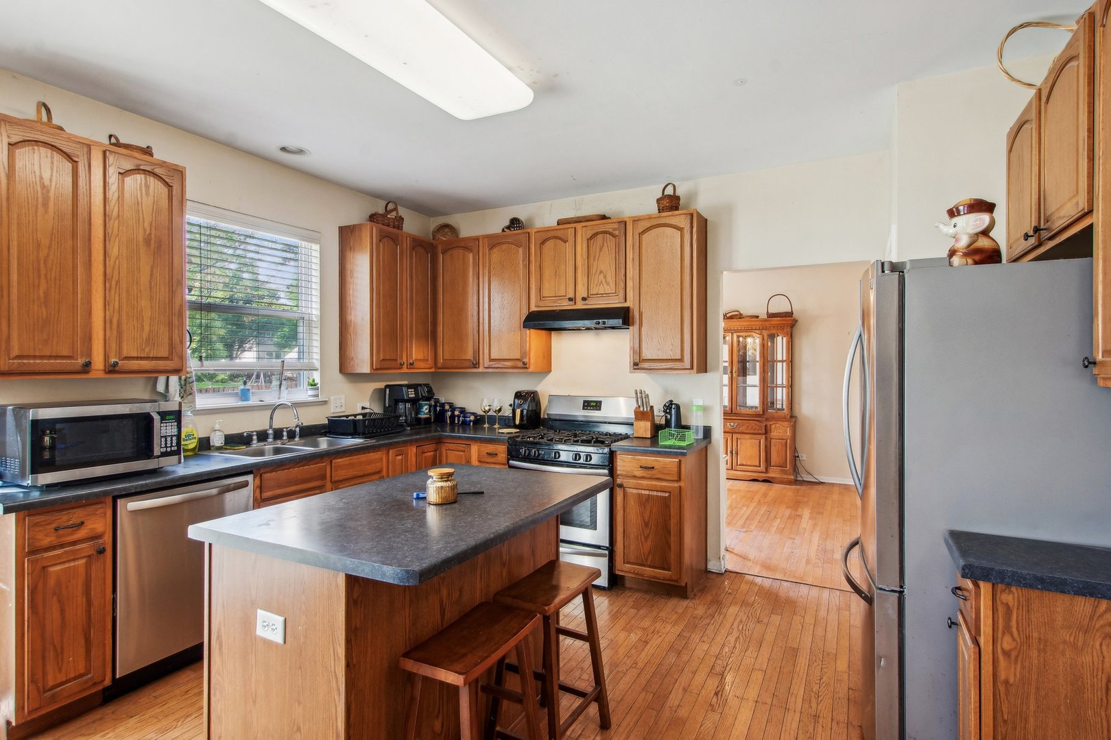 2673 Rourke Drive Aurora, IL 60503 - Photo 5 of 37 a kitchen with stainless steel appliances granite countertop a stove top oven a refrigerator a sink and dishwasher with wooden floor