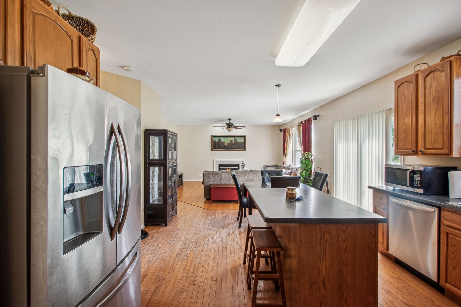 2673 Rourke Drive Aurora, IL 60503 - Photo 6 of 37 a kitchen with stainless steel appliances granite countertop a refrigerator a stove a sink dishwasher a dining table and chairs with wooden floor